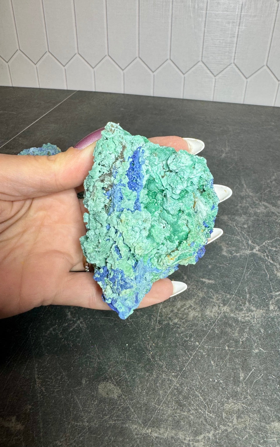 Azurite and malachite specimen held in hand