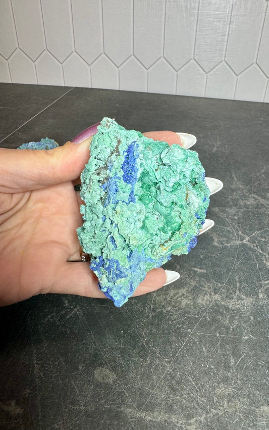 Azurite and malachite specimen held in hand