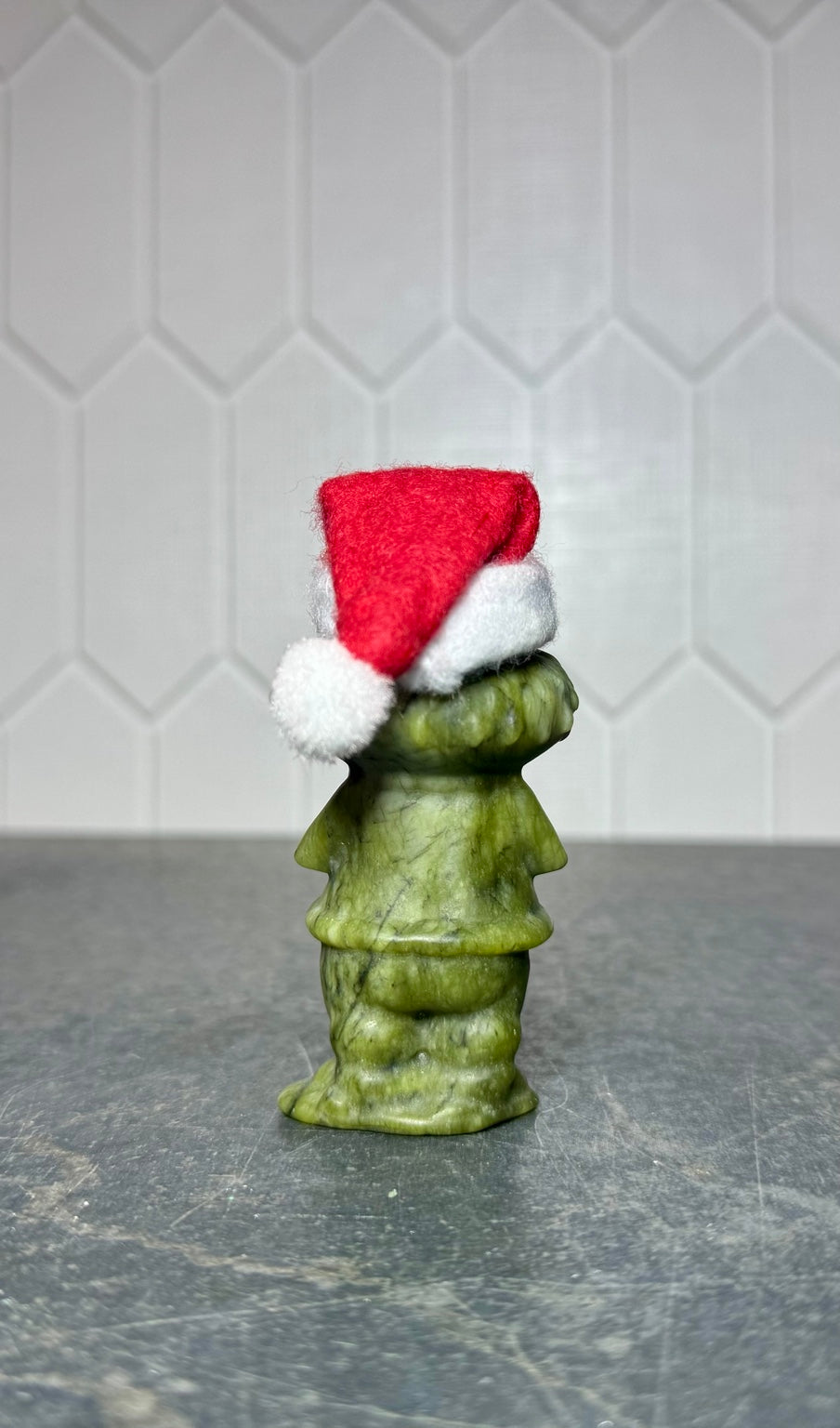 Large green jade Grinch carving with Santa hat, back view