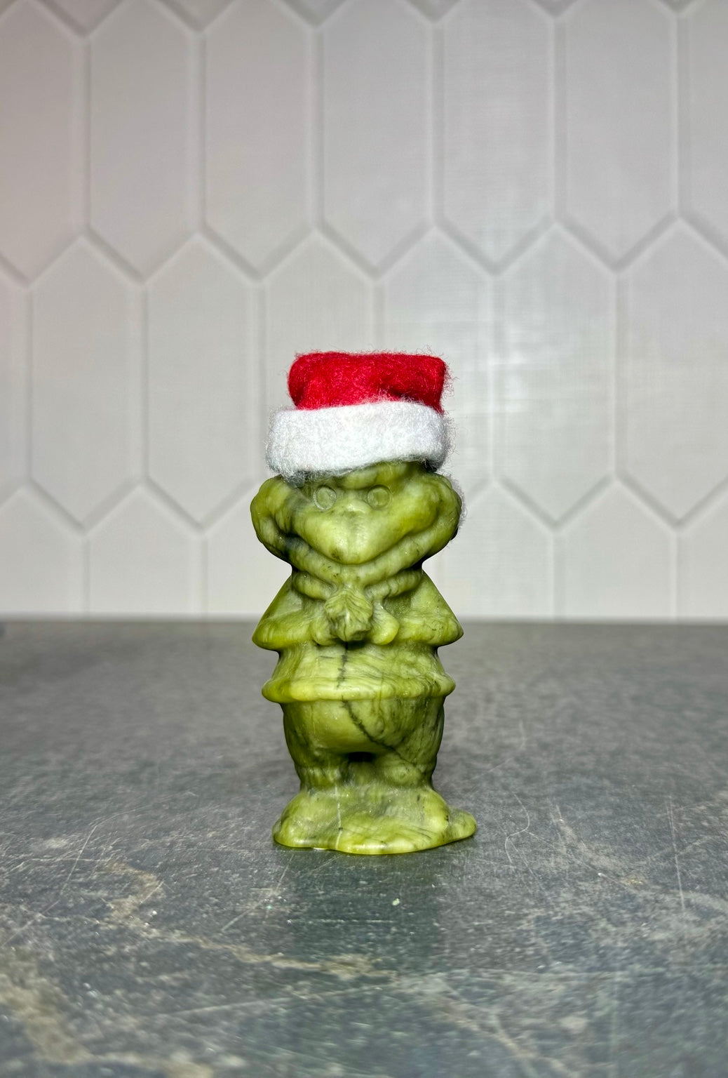 Large green jade Grinch carving with Santa hat, front view