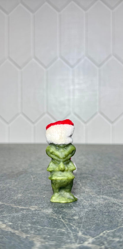 Small green jade Grinch carving with Santa hat, front view